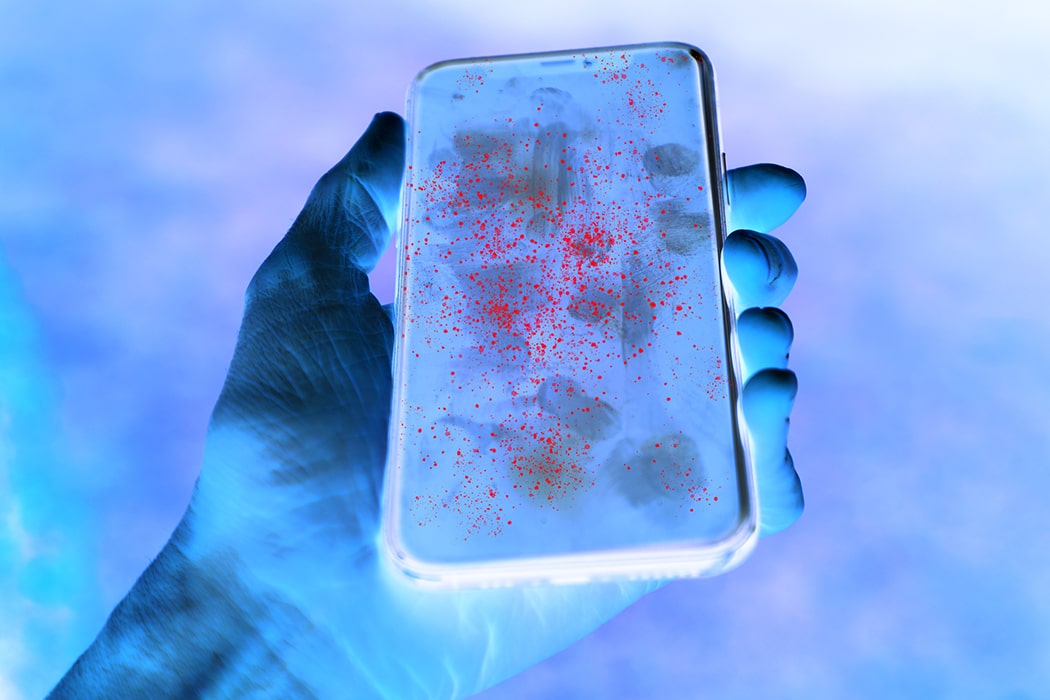 Hand and phone with red germs on the surface of the phone due to UV editing